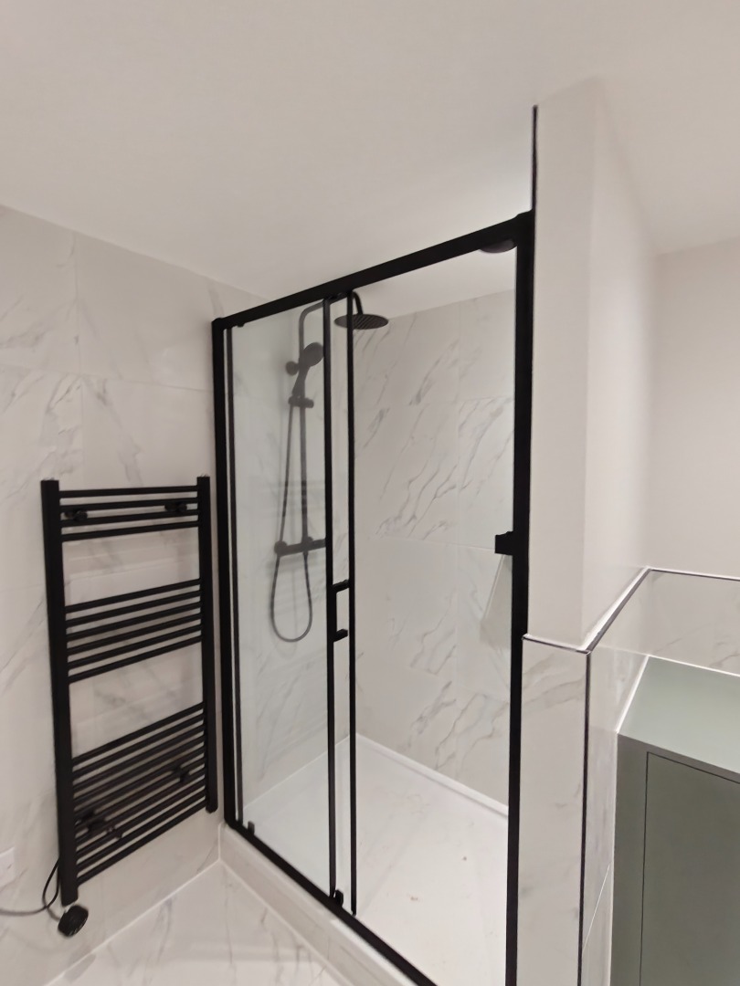 Bathroom with black-framed shower and marble tiling
